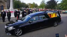 Warga berbaris saat mobil yang membawa peti berisi jenazah Ratu Elizabeth II melintas di Ballater, Skotlandia, Minggu (11/9/2022). Jenazah Ratu Elizabeth II diberangkatkan dari Kastil Balmoral ke Istana Holyroodhouse di Edinburgh sebelum nantinya akan dipindahkan ke London. (Andrew Milligan/PA via AP)
