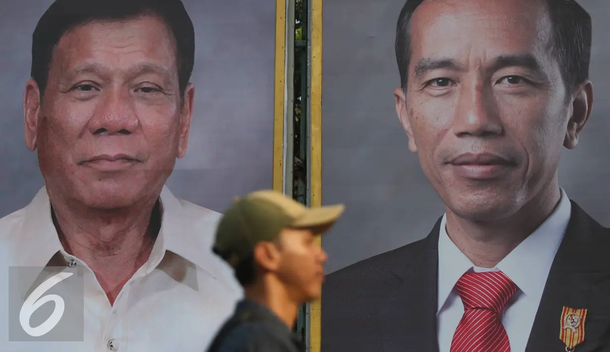 Warga melintas di depan foto Jokowi dan Duterte di Taman Pandang Istana, Jakarta, Kamis (8/9). Rencananya Duterte akan berkunjung ke Indonesia pada Jumat (9/9). (Liputan6.com/Immanuel Antonius)