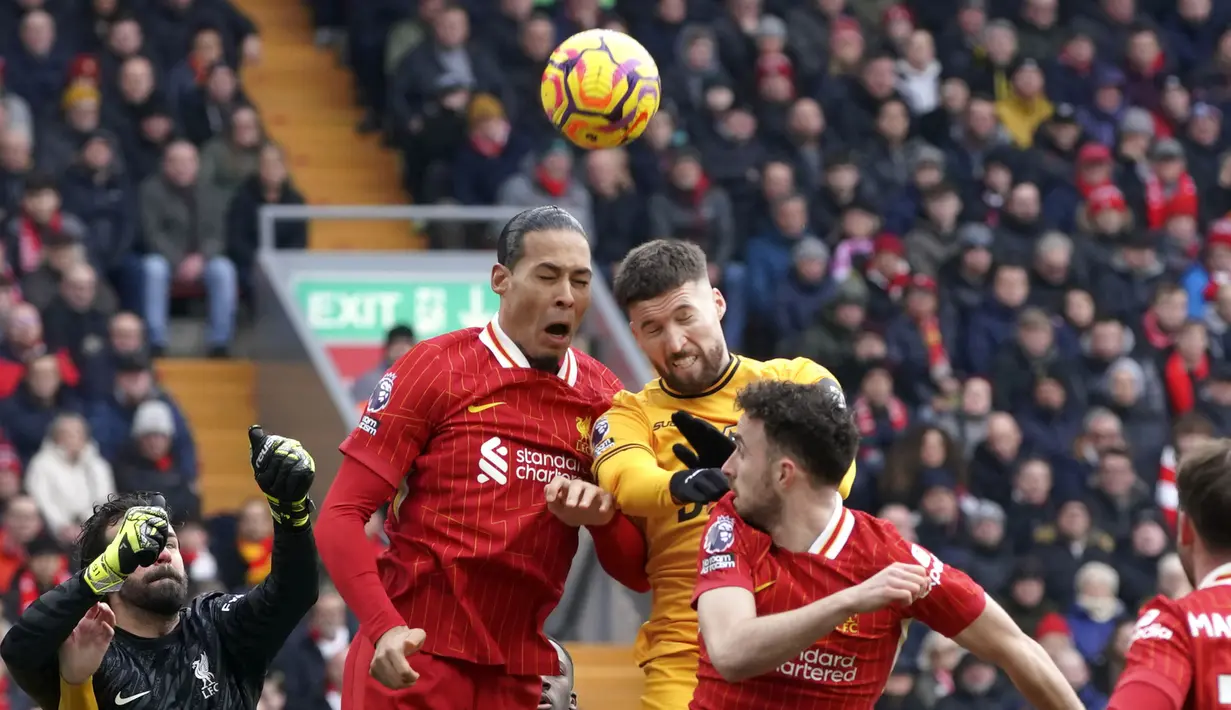Pemain Liverpool, Virgil Van Dijk (kiri) berduel udara dengan pemain Wolverhampton dalam laga lanjutan Liga Inggris 2024/2025 di Anfield, Liverpool, Inggris, Minggu (16/02/2025). (AP Photo/Ian Hodgson)