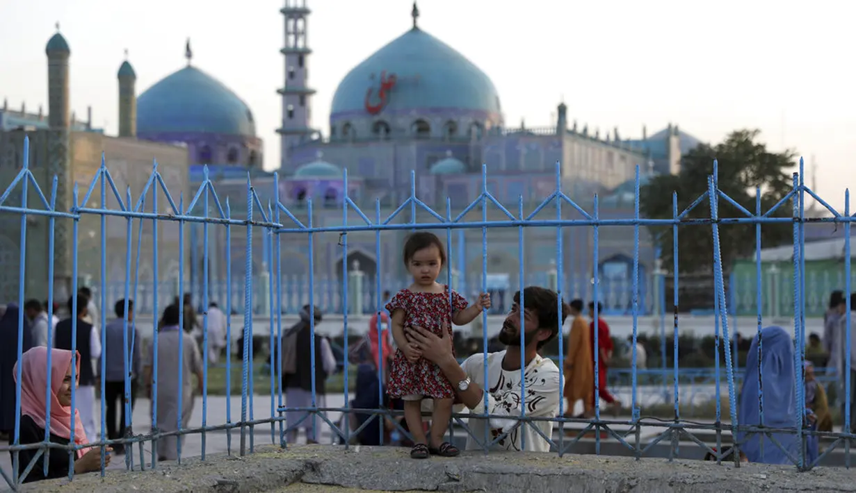 Seorang anak berpose untuk difoto saat mengunjungi Hazrat-e-Ali atau Masjid Biru di Mazar-e-Sharif, Afghanistan, Rabu (7/7/2021). Masjid Biru adalah tempat yang diminati orang-orang untuk menikmati ketenangan dari hiruk jalanan dan keramaian aktivitas pasar. (AP Photo/Rahmat Gul)