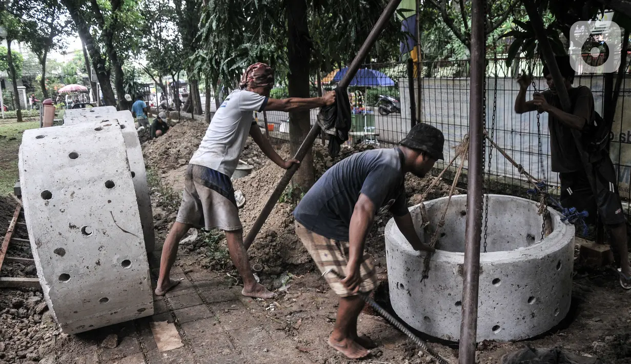 Pekerja menyelesaikan pembangunan sumur resapan di RPTRA Meruya Utara, Jakarta, Selasa (25/1/2022). Pembangunan 100 titik sumur resapan ini bertujuan untuk mengantisipasi banjir yang kerap terjadi di wilayah tersebut. (merdeka.com/Iqbal S. Nugroho)
