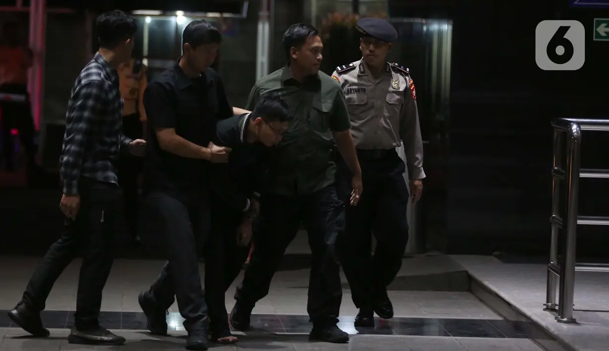 Petugas Komisi Pemberantasan Korupsi (KPK) menggiring orang yang mengaku-aku sebagai pegawai KPK di Gedung Merah Putih KPK, Jakarta, Rabu (5/2/2025). (Liputan6.com/Helmi Fithriansyah)