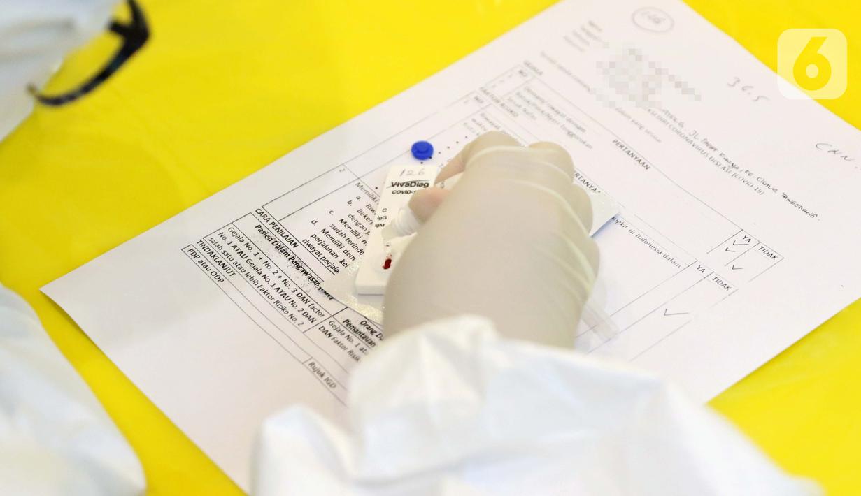 Petugas medis melakukan tes saat Rapid Test COVID-19 di Jakarta, Rabu (8/4/2020). Hasil akan memperlihatkan adanya IgG atau IgM dalam darah. Jika ada, maka hasil dinyatakan positif. Namun, hasil tersebut bukanlah diagnosis yang menggambarkan infeksi Covid-19. (Liputan6.com/Helmi Fithriansyah)