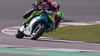 Pembalap Italia Petronas Yamaha SRT Valentino Rossi (kanan) dan pembalap Spanyol Aprilia Racing Team, Aleix Espargaro (belakang) berkendara selama FP1 MotoGP Doha di Losail International Circuit, Jumat (2/4/2021). (KARIM JAAFAR / AFP)