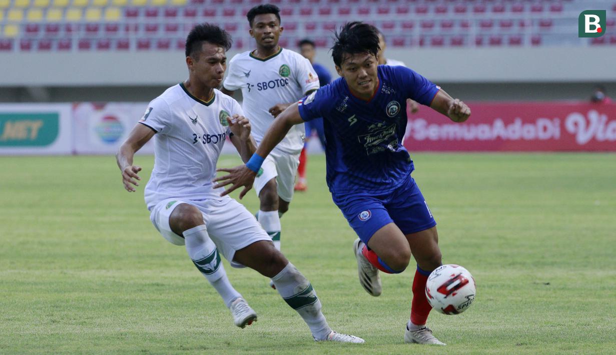 Striker Arema FC, Feby Eka Putra (kanan) menguasai bola dibayangi bek Persikabo 1973, Andy Setyo Nugroho dalam laga pembuka Piala Menpora 2021 di Stadion Manahan, Solo, Minggu (21/3/2021). Arema FC bermain Imbang 1-1 dengan Persikabo 1973. (Bola.com/M Iqbal Ichsan)