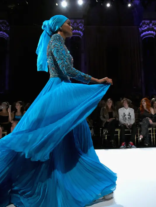 Model Halima Aden berjalan di atas catwalk menggenakan busana rancangan Sherri Hill Show selama New York Fashion Week 2019 di New York City (8/2). Model 21 tahun ini merupakan model pertama yang menggunakan hijab. (AFP Photo/Ben Gabbe)