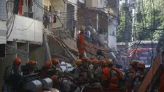 Petugas pemadam kebakaran mencari korban selamat setelah tertimpa puing-puing bangunan empat lantai yang runtuh di kawasan kumuh Rio das Pedras di Rio de Janeiro, Brasil (3/6/2021). Konstruksi tak beraturan di lingkungan kelas pekerja itu, ambruk sekitar pukul 03:20. (AP Photo/Bruna Prado)