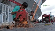 Pekerja memotong pipa untuk perbaikan pintu stadion yang rusak di Stadion Utama Gelora Bung Karno, Kamis (22/2/2018). Empat pintu stadion yang mengalami kerusakan adalah pintu bernomor 5B, 7B, 9, dan 10. (Bola.com/Nick Hanoatubun)