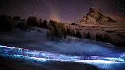 Foto menggunakan teknik kecepatan rendah menunjukkan sejumlah peserta berjalan di malam hari saat mengikuti lomba Patroli Gletser di resor ski Zermatt, Swiss (17/4). (Valentin Flauraud/Keystone via AP)