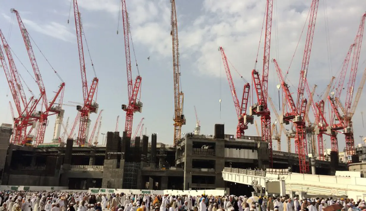 Ribuan umat muslim yang sedang menunaikan ibadah haji berjalan melintasi puluhan crane Masjidil  Haram, Mekah,  Arab Saudi (9/12/2015). Tragedi crane jatuh yang menewaskan 107 calon jemaah haji diakibatkan karena cuaca buruk. (AFP PHOTO / AHMED FARWAN)
