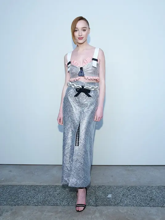Aktris asal Inggris, Phoebe Dynevor tampil nyentrik berbalut busana warna metallic dengan aksen ikat pinggang pita warna hitam. Tata rambut bintang film snatch ini pun dibiarkan sederhana dengan gaya ponytail. (Dok/Louis Vuitton).