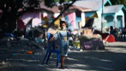 Seorang anak yang terkena dampak gempa meminta sumbangan pada pengguna jalan yang melintas di Donggala, Sulawesi Tengah, Jumat (5/10). Akibat terlambatnya pasokan bantuan, mereka terpaksa meminta sumbangan hingga turun ke jalan. (AFP PHOTO / Jewel SAMAD)