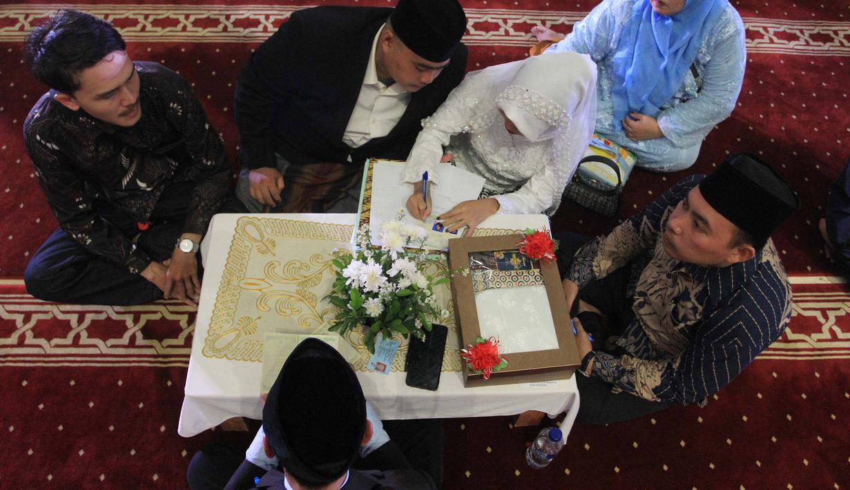 Selain memudahkan proses akad nikah, penyelenggara menanggung seluruh biaya proses dan kebutuhan administrasi. Tampak dalam foto, pasangan pengantin mengikuti Isbat nikah massal 2025 di Mesjid Istiqlal, Jakarta, Rabu (3/12/2025). (merdeka.com/Arie Basuki)