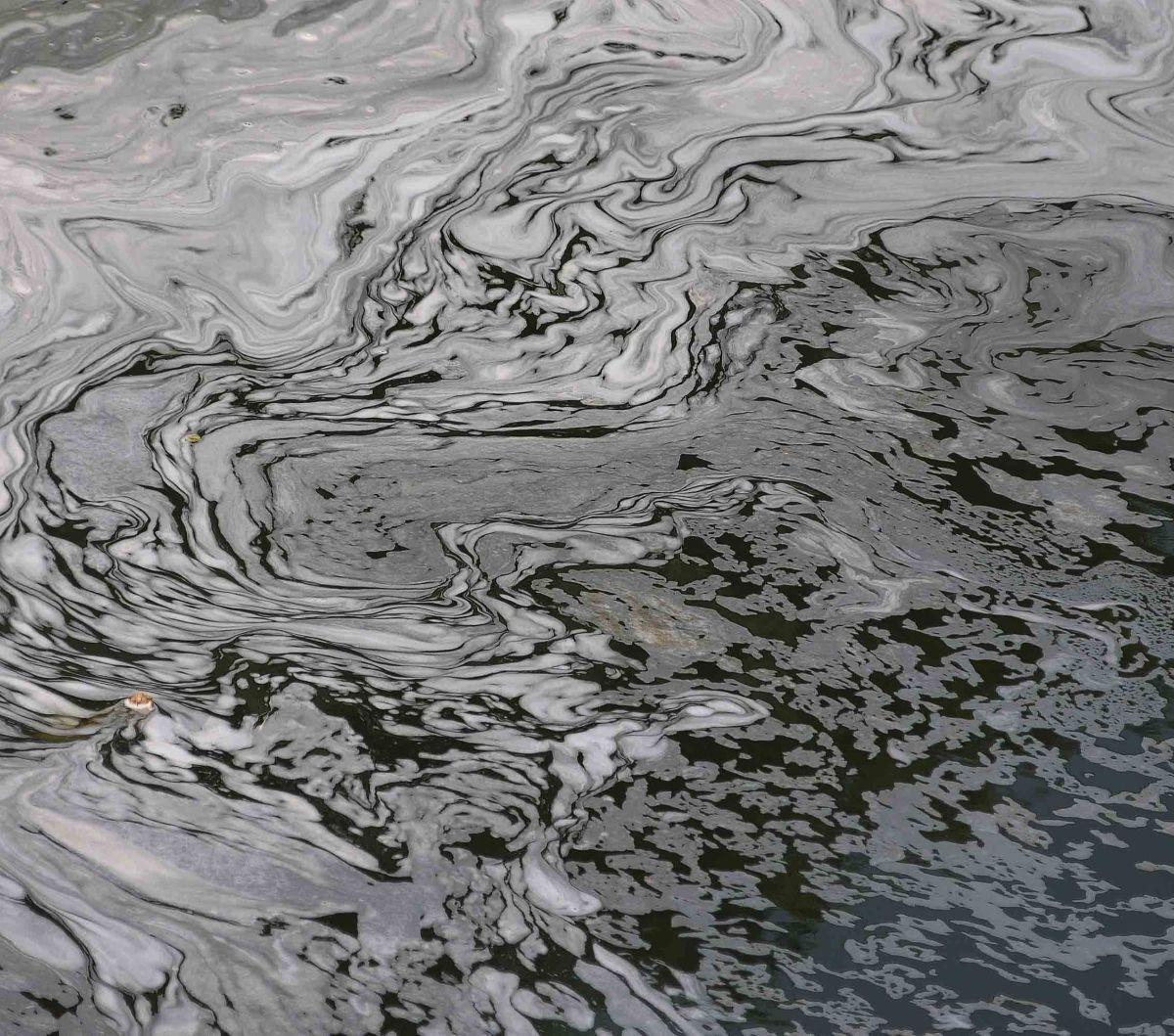 Busa putih yang berasal dari limbah deterjen tampak mengalir di Kanal Banjir Timur (KBT) setalah keluar dari pintu air Malaka Sari, Jakarta, Selasa (22/8/2023).