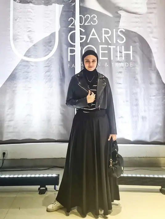 Di saat harus tampil formal, ia memilih jaket kulit dan paduan rok a-line bernuansa senada. Menyematkan sneakers yang menjadi favoritnya, ia tampak begitu energik. [Foto: Instagram/ Zeezeeshahab]