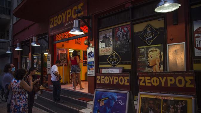 Calon penonton antre membeli tiket di bioskop terbuka Zephyros, Athena, Yunani, 1 Agustus 2020. Pandemi COVID-19 memaksa bioskop terbuka dipersingkat sehingga menyebabkan penurunan jumlah penonton. (ANGELOS TZORTZINIS/AFP)
