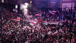 Suporter River Plate mengibarkan bendera saat merayakan gelar juara Copa Libertadores di Obelisk, Buenos Aires, Argentina, Minggu (9/12). River Plate merebut gelar juara Copa Libertadores usai menaklukkan Boca Juniors. (AP Photo/Gustavo Garello)