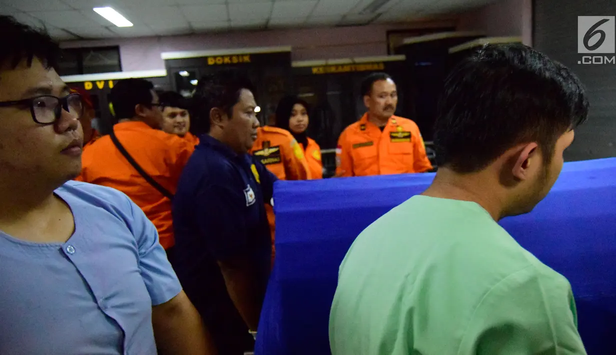 Petugas dan tim rumah sakit membawa membawa jenazah korban jatuh helikopter Basarnas di RS Bhayangkara Semarang (3/7). Delapan jenazah tersebut tiba di rumah sakit di Semarang secara bergiliran pada Senin (3/7/2017) dini hari. (Liputan6.com/Gholib)