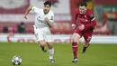 Gelandang Real Madrid, Marco Asensio berlari membawa bola dari kejaran bek Liverpool, Andrew Robertson pada pertandingan leg kedua babak perempat final Liga Champions di stadion Anfield di Liverpool, Inggris, Kamis (14/4/2021). Liverpool bermain imbang atas Madrid 0-0. (AP Photo/Jon Super)