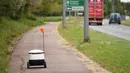 Robot otonom bernama Starship melakukan perjalanan untuk mengantarkan bahan makanan dari supermarket Co-op di Milton Keynes, Inggris, 20 September 2021. Robot Starship bertugas mengantarkan belanja dan makanan. (DANIEL LEAL-OLIVAS/AFP)