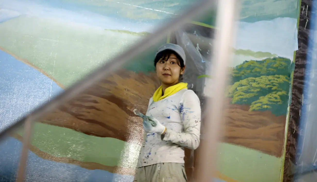  Mizuki Tanaka saat sibuk melukis gambar pemandangan Gunung Fuji di tembok suatu pemandian air panas atau sento  di pusat kota Tokyo,Jepang,  Jumat (2/10/2015). Hanya tersisa tiga orang di Jepang yang berprofesi sebagai pelukis sento. (REUTERS/Issei Kato)