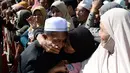 Seorang wanita mencium jemaah calon haji yang akan bertolak ke Tanah Suci Mekah di Bandara Provinsi Narathiwat, Thailand, Kamis (4/7/2019). Jutaan umat muslim dari penjuru dunia akan bertolak menuju Mekah untuk melangsungkan ibadah haji. (Madaree TOHLALA/AFP)