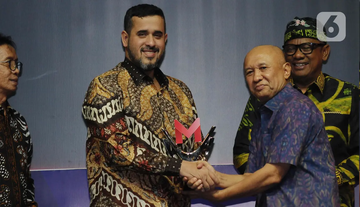 Menteri Koperasi dan Usaha Kecil Menengah Teten Masduki memberikan penghargaan Merdeka Award 2023 bidang Program Inovatif Pendampingan UMKM kepada Wali Kota Probolinggo Habib Hadi Zainal Abidin  di Gedung SCTV Tower, Jakarta, Rabu (30/8/2023). (merdeka.com/Imam Buhori)