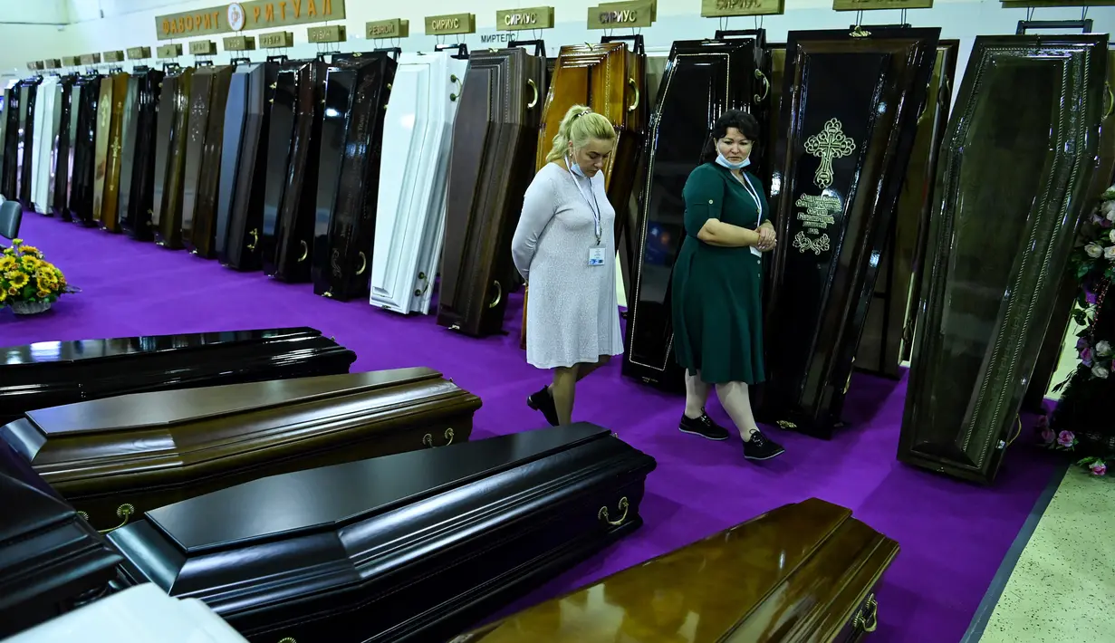 Peserta berjalan di antara peti mati selama pameran pemakaman di Moskow, Rusia pada Rabu (21/10/2020). (Photo by Kirill KUDRYAVTSEV / AFP)