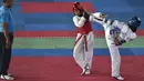Dua peserta perempuan saat bertarung dalam Kejuaraan Terbuka Taekwondo di Banda Aceh (17/7/2019). Ratusan peserta mengikuti turnamen yang memperebutkan Piala Pemerintah Aceh. (AFP Photo/Chaideer Mahyuddin)