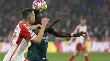 Bek Bayern Munchen Raphael Guerreiro berebut bola dengan penyerang Arsenal Bukayo Saka pada duel leg kedua perempat final Liga Champions 2023/2024 di Allianz Arena pada Kamis (18/4/2024) dinihari WIB. (AP Photo/Matthias Schrader)