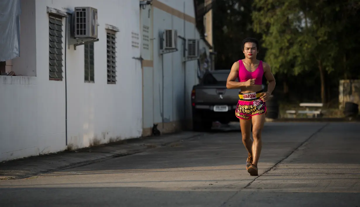 Petinju Muay Thai Nong Rose berlari saat melakukan latihan di provinsi Chachoengsao, Thailand (15/12). Nong Rose berlatih untuk mempersiapkan pertandingannya di Prancis. (AFP Photo)
