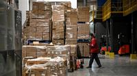 Seorang pekerja bersiap mentransfer paket untuk pengiriman menjelang festival belanja Singles' Day yang jatuh pada 11 November, di gudang JD.com di Beijing, Selasa (9/11/2021). Hari belanja online nasional atau single day di China menjadi festival belanja online terbesar di dunia. (Giok GAO / AFP)