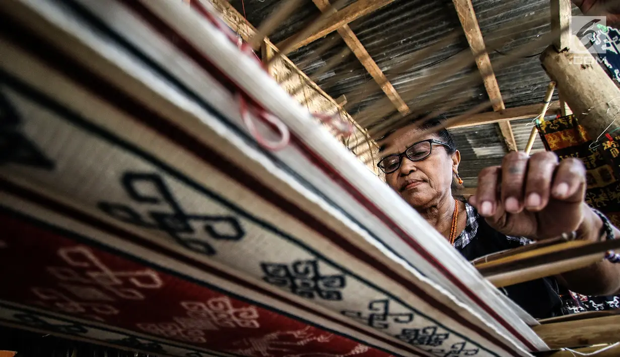 Mama Adriana Rambuadji membuat kain tenun di Desa Adat Prailiu, Sumba Timur, NTT, Sabtu (15/12). Pembuatan kain tenun di desa ini menjadi mata pencarian warga. (Liputan6.com/JohanTallo)