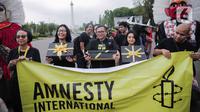Aktivis yang tergabung dalam Amnesty Internasional Indonesia menggelar aksi di depan Istana Negara, Jakarta, Selasa (10/12/2019). Aksi tersebut digelar untuk memperingati Hari HAM Sedunia 2019. (Liputan6.com/Faizal Fanani)