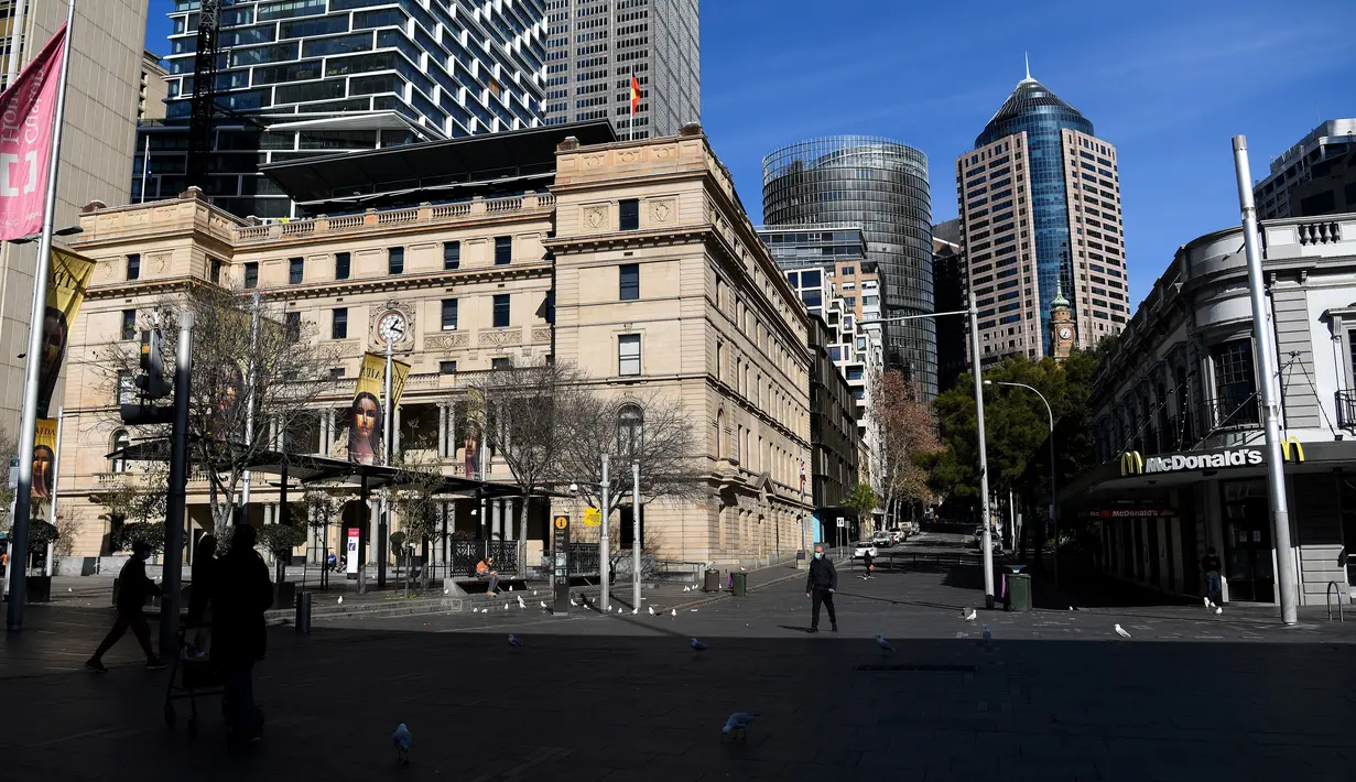 Orang-orang berjalan melalui kawasan pusat bisnis yang kosong di Sydney, Selasa (6/7/2021). PM negara bagian New South Wales Gladys Berejiklian mengutarakan pihaknya akan memutuskan apakah akan memperpanjang lockdown di Sydney atau tidak yang harusnya berakhir pada 9 Juli 2021 (Bianca De Marchi/AFP)