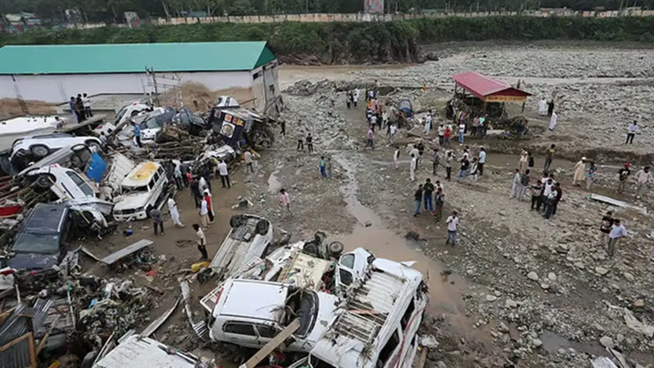 Warga melihat kendaraan yang rusak setelah banjir bandang dan tanah longsor akibat hujan deras melanda Distrik Rajouri di wilayah Jammu, India, pada Minggu (19/7/2026).