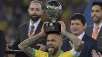 Kapten Timnas Brasil, Dani Alves, mengangkat trofi Copa America 2019 di Stadion Maracana, Rio de Janeiro, Brasil, (AFP/Carl De Souza)
