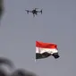 Sebuah drone mengibarkan bendera nasional Irak saat perayaan keberhasilan menyingkirkan militan ISIS dari Kota Tua Mosul, Minggu (9/7). Irak memulai pertempuran merebut Mosul pada Oktober lalu dengan dukungan dari koalisi pimpinan AS. (FADEL SENNA/AFP)