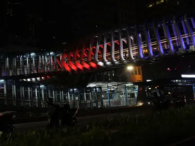 Warna lampu seperti bendera Selandia Baru terlihat di JPO Gelora Bung Karno, Jakarta, Minggu (17/3). Pencahayaan tematik ini sebagai tanda berdukacita atas peristiwa penembakan keji di Kota Christchurch, Selandia Baru. (Liputan6.com/Helmi Fithriansyah)