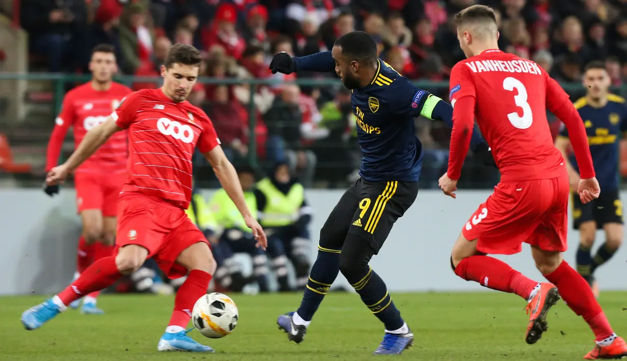 Pemain Arsenal Alexandre Lacazette (tengah) berusaha melewati pemain Standard Liege pada pertandingan Grup F Liga Europa di Stadion Maurice Dufrasne, Liege, Belgia, Kamis (12/12/2019). Arsenal juara grup setelah menahan Standar Liege 2-2. (AP Photo/Francois Walschaerts)