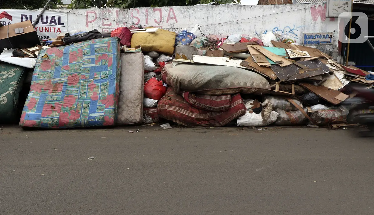 Tumpukan sampah terlihat menumpuk di sepanjang jalan pascabanjir mulai surut di kawasan Kembangan, Jakarta Barat, Minggu (5/1/2020). Pasca banjir yang melanda hampir di kawasan Jakarta mulai surut, tumpukan sampah terlihat di sepanjang jalan dari rumah-rumah warga. (Liputan6.com/Johan Tallo)