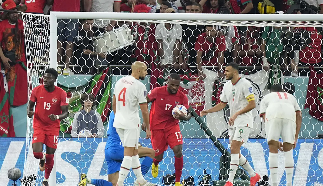 Pemain Kanada, Cyle Larin mengangkat bola di samping pemain Maroko, Nayef Aguerd selama pertandingan grup F Piala Dunia 2022 di Stadion Al Thumama di Doha, Qatar, Kamis (1/12/2022). Maroko menang tipis atas Kanada dengan skor 2-1. (AP Photo/Pavel Golovkin)