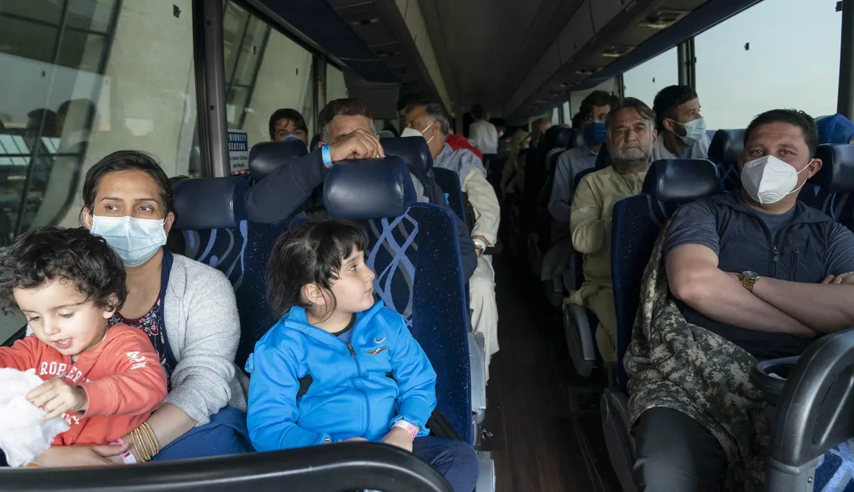 Keluarga dievakuasi dari Kabul, Afghanistan, menunggu di dalam bus setelah mereka tiba di Bandara Internasional Washington Dulles, di Chantilly, Va Rabu (25/8/2021). (AP Photo/Jose Luis Magana)