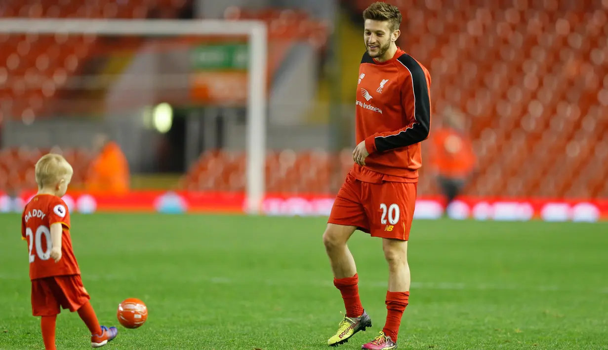 Gelandang Liverpool Adam Lallana bermain bola dengan anaknya di dalam lapangan usai bertanding melawan Chelsea pada pertandingan Liga Inggris di Anfield, Liverpool, 12 Mei 2016. (Reuters / Carl Recine)