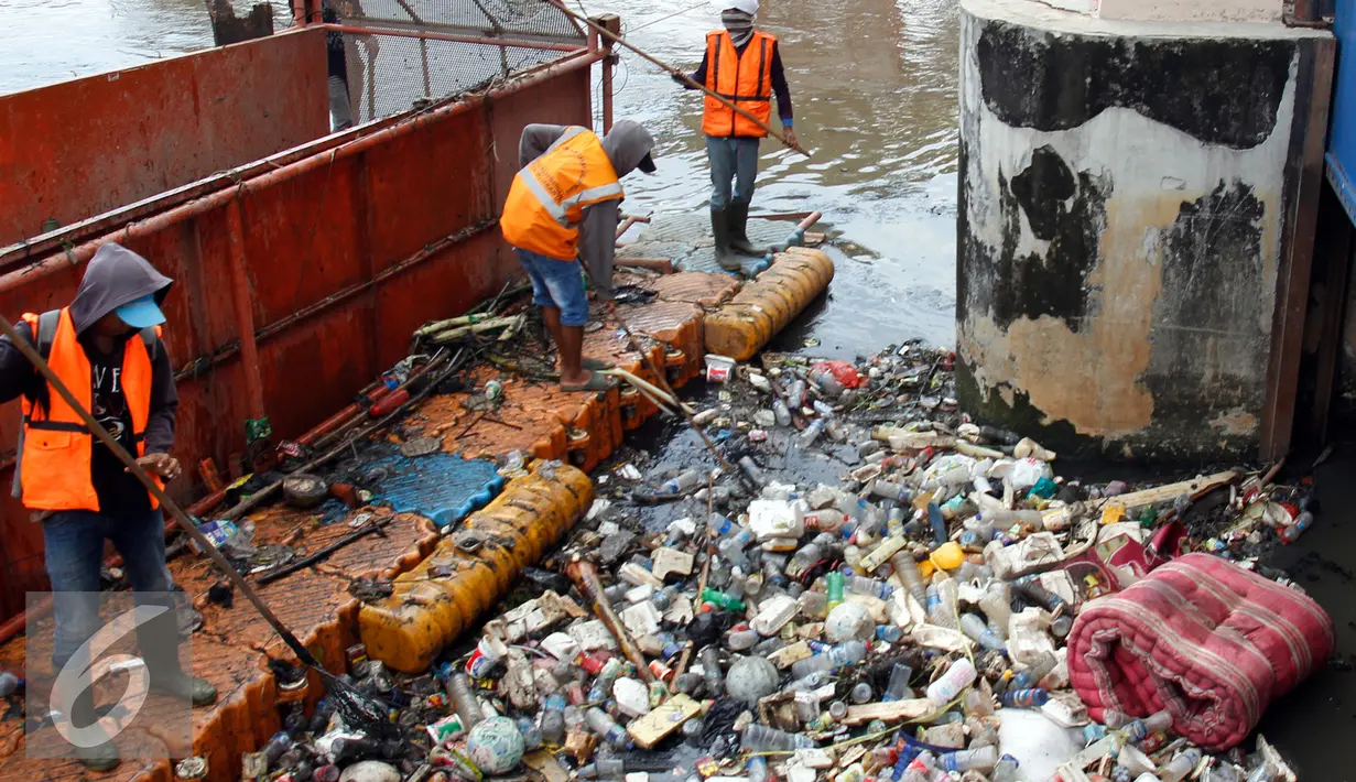 Petugas dari Dinas Kebersihan mengangkut sampah yang tersangkut di Pintu Air, Jakarta, Jum'at (30/9). Perawatan Pintu Air dari tumpukan sampah yang tersangkut agar buka tutup pintu air Jembatan Hanging dapat maksimal. (Liputan6.com/Johan Tallo)