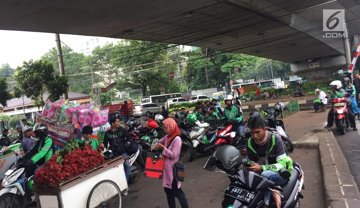 Pengemudi ojek online memadati kolong flyover Kalibata, Jakarta, Rabu (17/1). Kurangnya penegakan hukum menyebabkan banyak pengemudi ojek online mangkal di kolong flyover tersebut sehingga kerap mengganggu lalu lintas. (Liputan6.com/Immanuel Antonius)