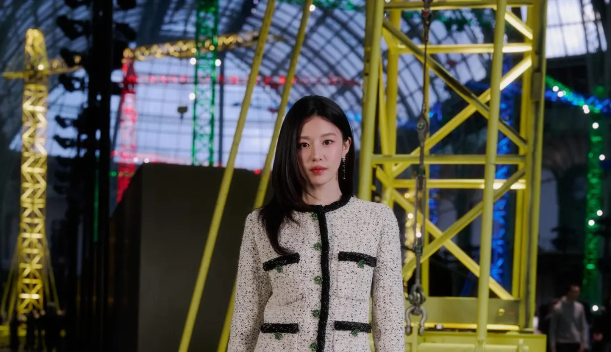 Aktris Korea Selatan Go Youn-jung membawa nuansa klasik Chanel lewat setelan tweed putih yang terdiri dari cropped jacket dan mini skirt. Detail trimming hitam serta kantong kecil khas Chanel memperkuat estetika maison yang timeless.