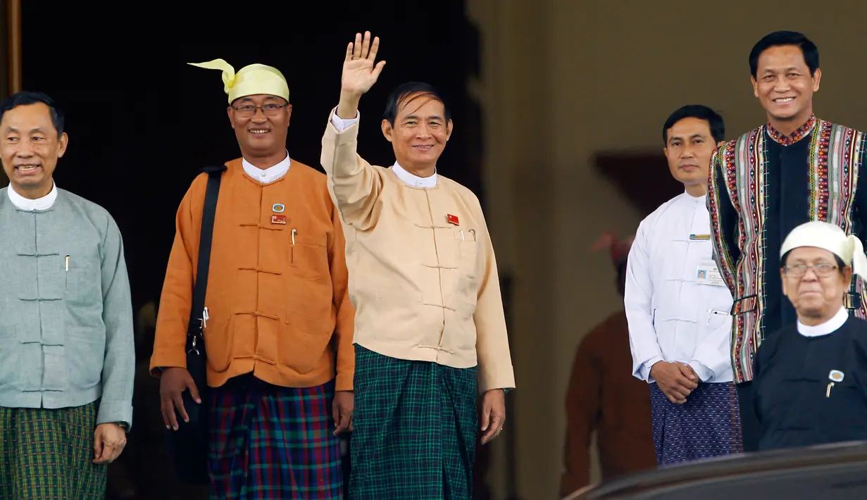 Presiden Myanmar yang baru terpilih Win Myint melambaikan tangan kepada media di luar parlemen di Naypyitaw, Rabu (28/3). Dia menyisihkan dua kandidat presiden lain, salah satunya calon yang didukug militer Myanmar, Myint Swe. (AP/Aung Shine Oo)