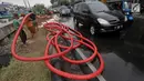 Pekerja merapikan kabel jaringan utilitas ke dalam tanah di kawasan Kemayoran, Jakarta, Minggu (14/1). PT PLN Disjaya akan menertibkan kabel listrik yang ada di tiang-tiang dengan menanam kabel di bawah tanah. (Liputan6.com/Immanuel Antonius)