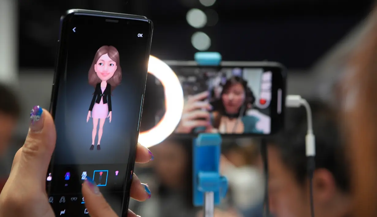 Seorang wanita mencoba ponsel Samsung Galaxy S9 saat acara Samsung Galaxy S9 Unpacked di Barcelona, Spanyol (25/2). Samsung akan menjual kedua smartphone ini sebulan setelah peluncurannya, yakni April 2018. (AFP Photo/Lluis Gene)